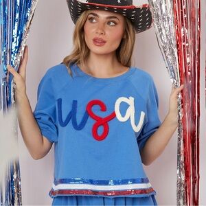Wild Indigo crop top featuring "USA" yarn embroidery and a sequin-trimmed hem